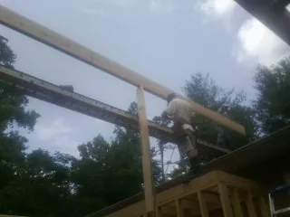 Carpenter setting a ridge beam over a new addition frame — Ice Dam Removal by Roofing Brothers in Hickory Corners