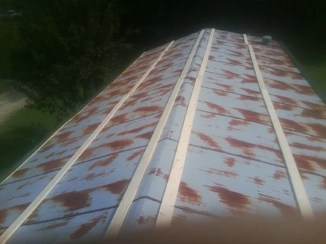 Rusted metal roof panels with new wood purlins before replacement — Storm Damage Roof Repair in Hickory Corners by Roofing Brothers
