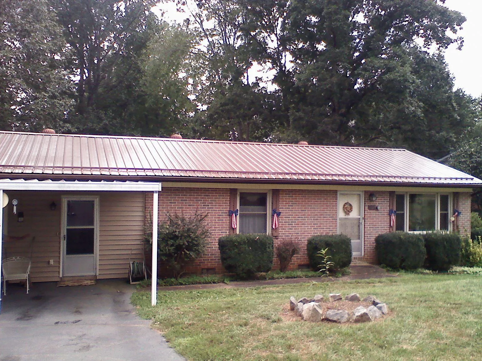 Bronze metal roof and carport on a brick ranch home — Roof Repair work by our crew in Hickory Corners