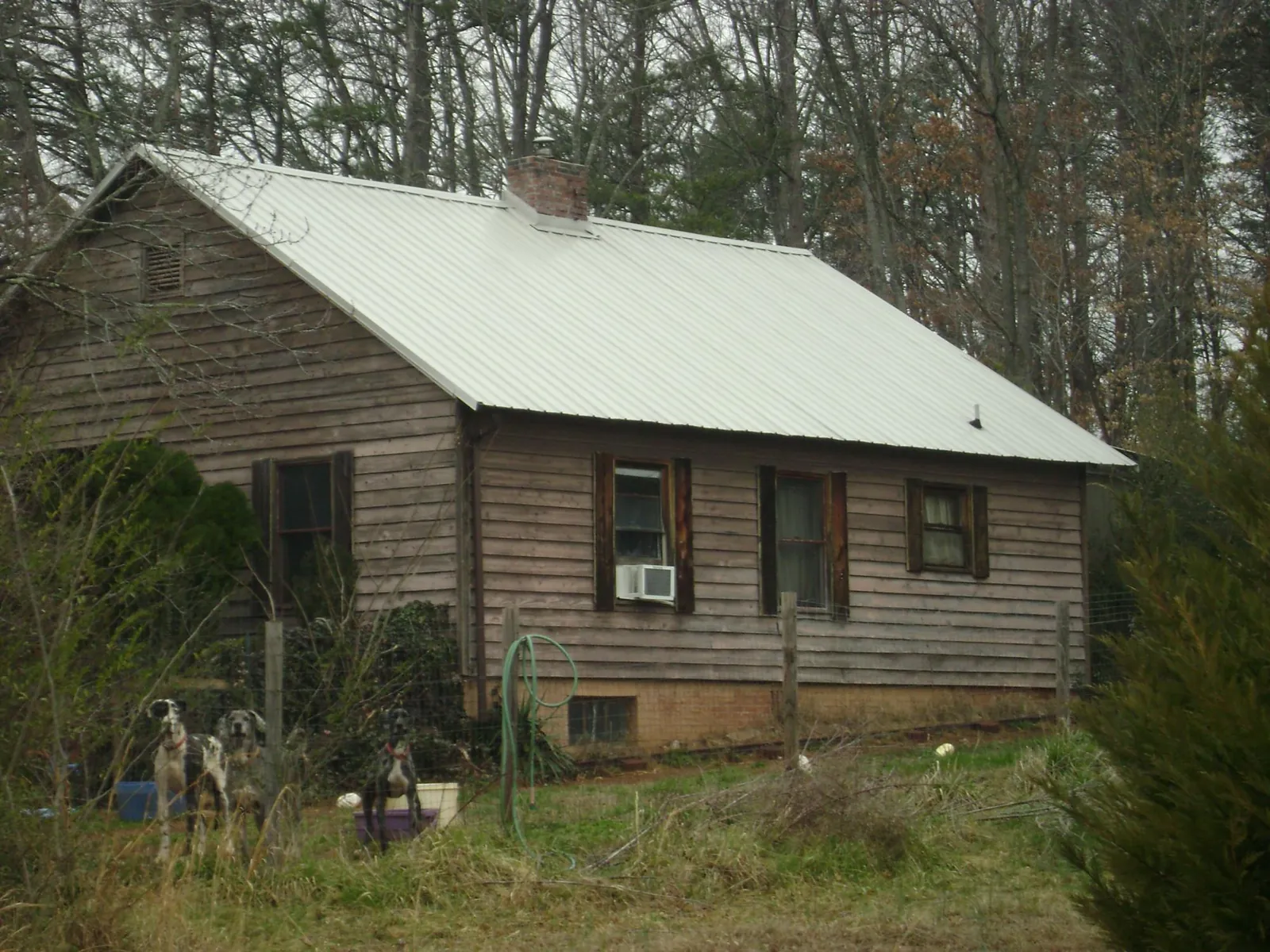 White metal roof on an old wood sided farmhouse, from a Metal Roof Installation job in Hickory Corners